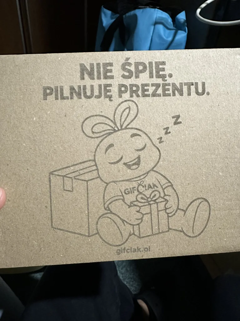Karton Gifciak z grawerem: śpiący Gifciak z prezentem przy pudełku i napis „Nie śpię. Pilnuję prezentu”